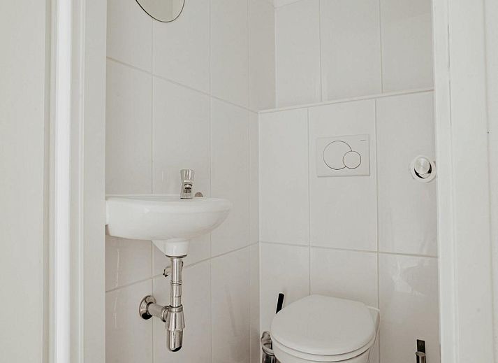 Stilvolles Wohnzimmer des Ferienhauses Nova Meer in Uitgeest, Nordholland, mit moderner Einrichtung und gruenen Akzenten.