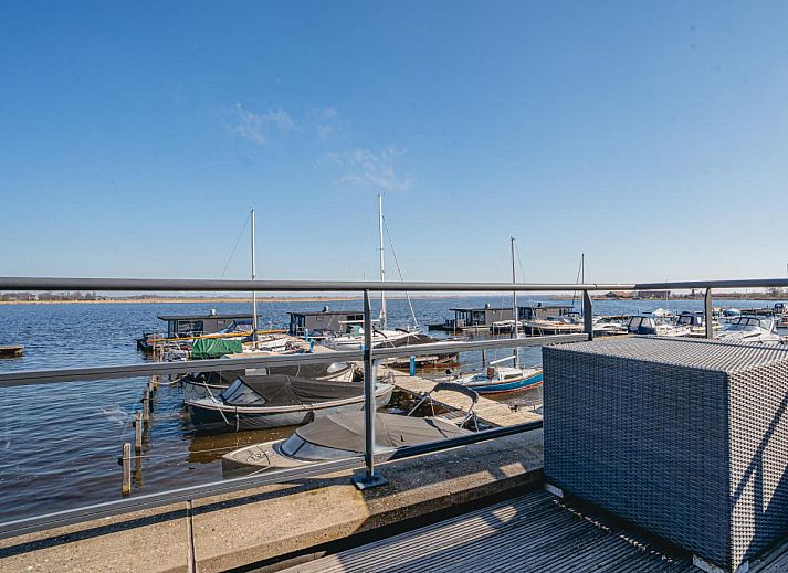 Stilvolles Wohnzimmer des Ferienhauses Nova Meer in Uitgeest, Nordholland, mit moderner Einrichtung und gruenen Akzenten.