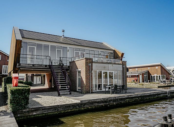Geraeumiges Wohnzimmer der Penthouse-Wohnung in Uitgeest, Nordholland, mit modernen Moebeln und viel natuerlichem Licht.