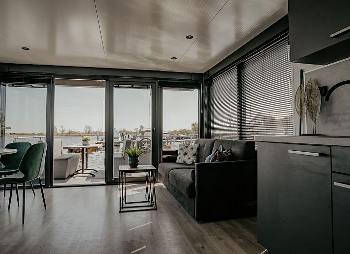 Gezellige eethoek met uitzicht op het water in Vakantiehuis Havenlodge, Uitgeest, Noord-Holland.