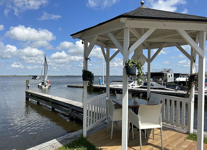 Lichte binnenruimte met terrasuitzicht in Vakantiehuis Havenlodge, Uitgeest, Noord-Holland.