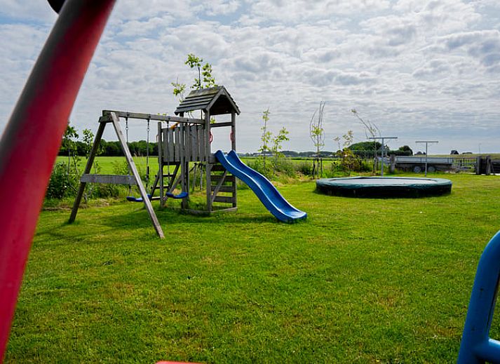 Gemuetliches Wohnzimmer von Huisje in Ursem, Ferienhaus in Nordholland, mit bequemen Sofas und Gartenblick.