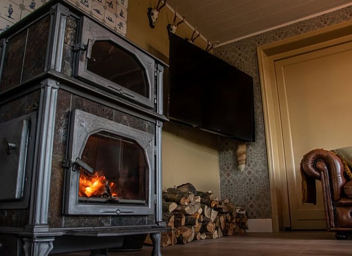 Gemuetliches Wohnzimmer von Huisje in Ursem, Ferienhaus in Nordholland, mit bequemen Sofas und Gartenblick.