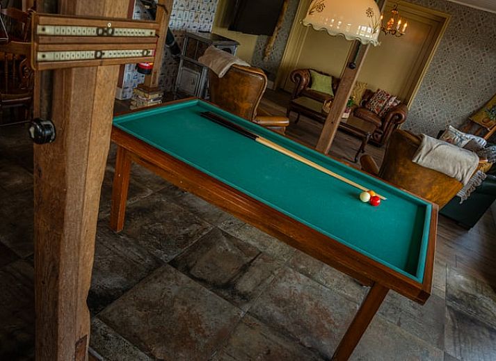 Geraeumiger Innenbereich des Huisje in Ursem, Ferienhaus in Nordholland, mit Billardtisch und gemuetlicher Sitzecke.