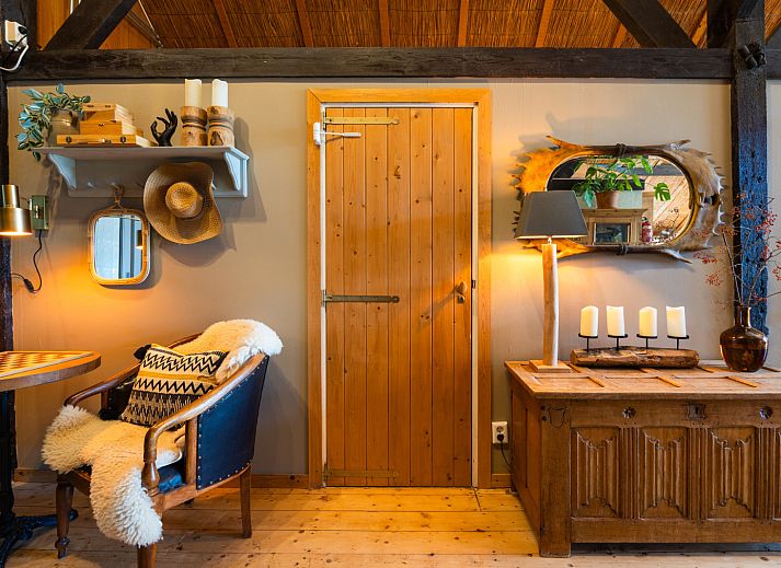 Buitenveranda van NH135 vakantiehuis in Schermerhorn, Noord-Holland, omgeven door groen.