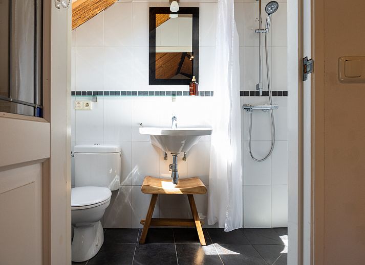 Buitenveranda van NH135 vakantiehuis in Schermerhorn, Noord-Holland, omgeven door groen.