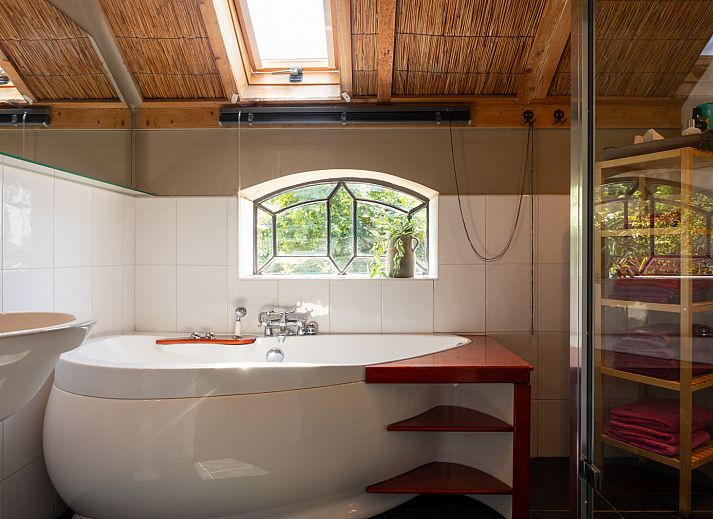 Buitenveranda van NH135 vakantiehuis in Schermerhorn, Noord-Holland, omgeven door groen.