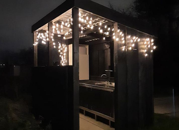 Openstaande deuren van Huisje in Zuid-Scharwoude, een vakantiehuis in Noord-Holland, met uitnodigend interieur.