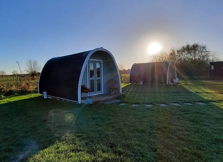 Openstaande deuren van Huisje in Zuid-Scharwoude, een vakantiehuis in Noord-Holland, met uitnodigend interieur.
