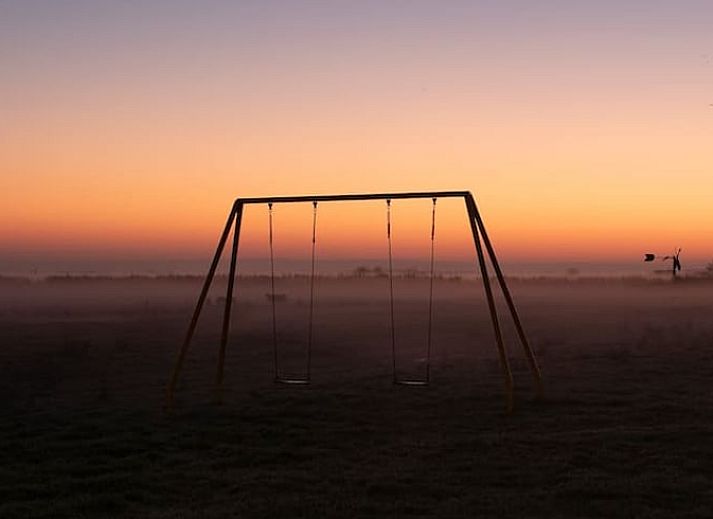 Stijlvolle zithoek in Huisje in Oostknollendam, vakantiehuis in Noord-Holland, met houten interieur en ruime ramen.