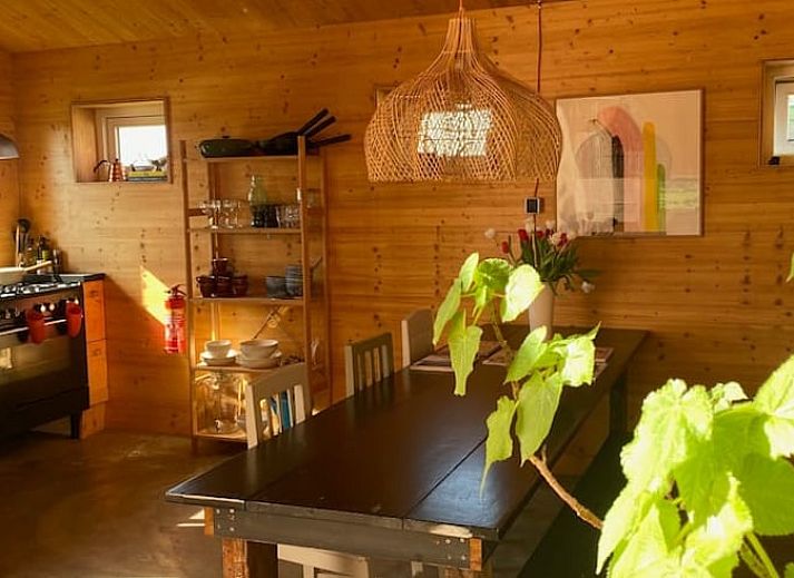 Stijlvolle zithoek in Huisje in Oostknollendam, vakantiehuis in Noord-Holland, met houten interieur en ruime ramen.