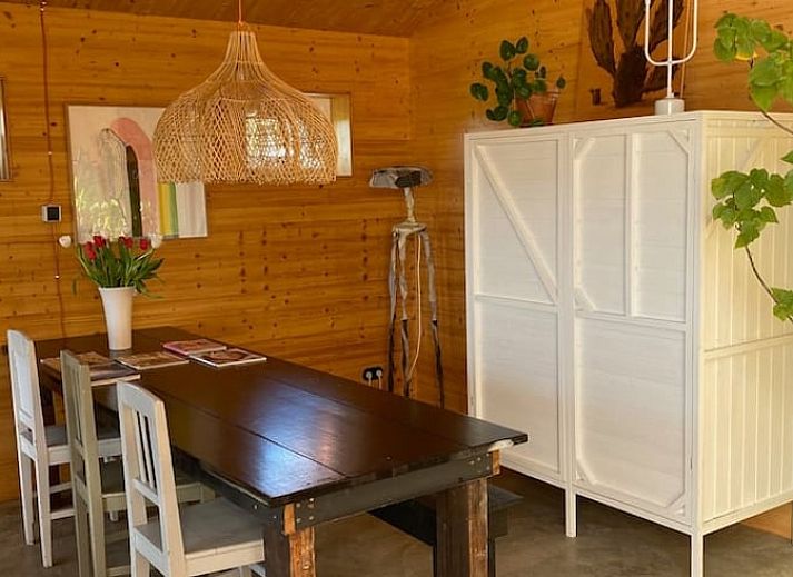 Stijlvolle zithoek in Huisje in Oostknollendam, vakantiehuis in Noord-Holland, met houten interieur en ruime ramen.