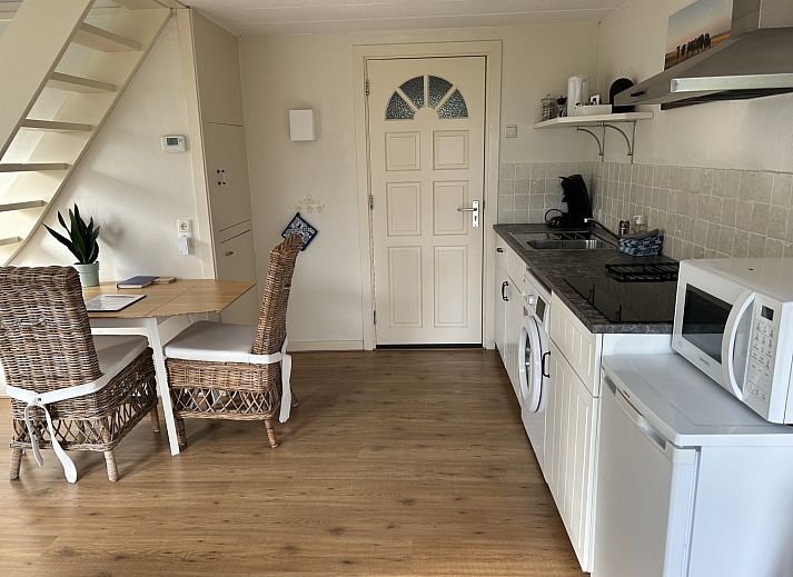 Sonnenterrasse des Ferienhauses NH539 in Spanbroek, Nordholland mit Blumen und Sitzgelegenheit