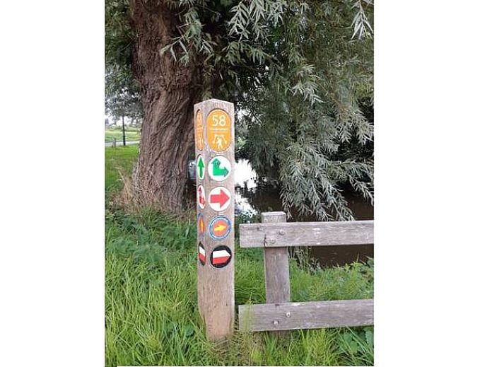 Cozy living room in Holiday Home in Driehuizen, North Holland, with comfortable sofa and garden view.