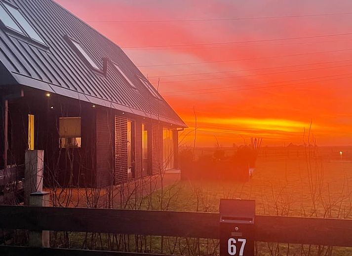 Comfortabele slaapkamer in Vakantiehuisje in Markenbinnen, Noord-Holland, met kleurrijke accenten en toegang tot balkon.