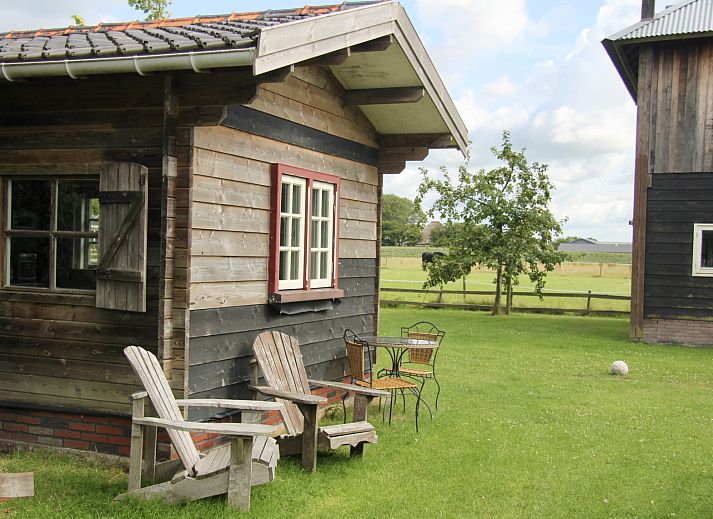 NH550 vakantiehuis in Heerhugowaard met knusse houten veranda en groene tuin in Noord-Holland.