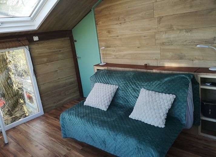 Blick auf die Felder von der Terrasse des Ferienhauses in West Beemster, Ferienhaus in Nordholland, mit Holztisch und Stuehlen.