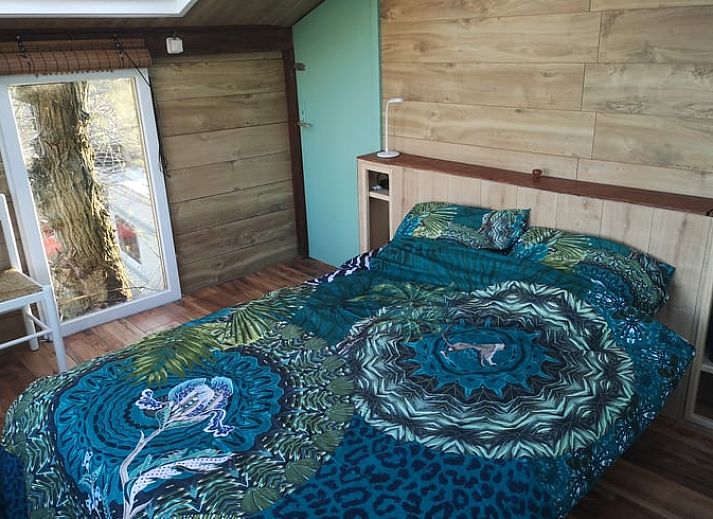 Blick auf die Felder von der Terrasse des Ferienhauses in West Beemster, Ferienhaus in Nordholland, mit Holztisch und Stuehlen.