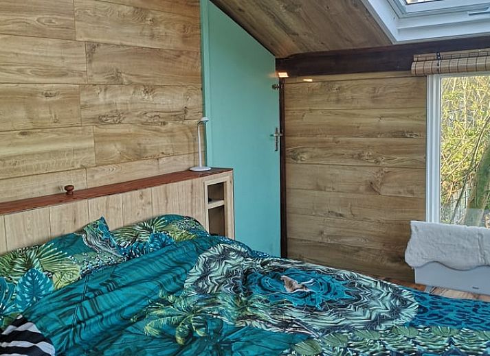 Blick auf die Felder von der Terrasse des Ferienhauses in West Beemster, Ferienhaus in Nordholland, mit Holztisch und Stuehlen.