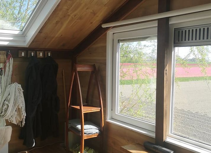 Blick auf die Felder von der Terrasse des Ferienhauses in West Beemster, Ferienhaus in Nordholland, mit Holztisch und Stuehlen.