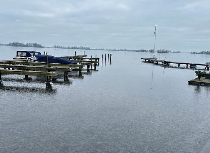 Terrasse des Ferienhauses in Loosdrecht, Nordholland, mit Blick auf die Loosdrechter Seen und bequemen Stuehlen.