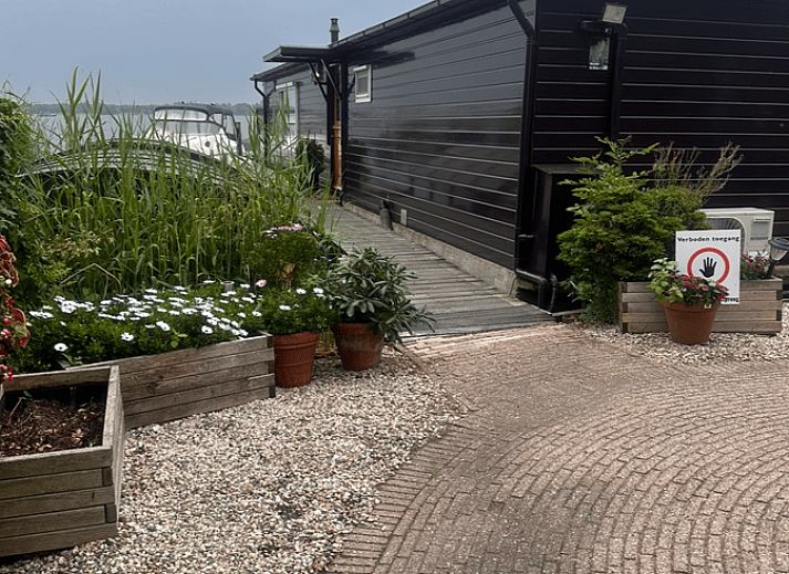 Terrasse des Ferienhauses in Loosdrecht, Nordholland, mit Blick auf die Loosdrechter Seen und bequemen Stuehlen.