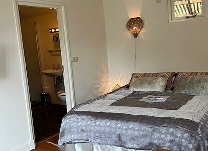 Gemuetliche Kueche im Ferienhaus in Naarden, Nordholland, mit blauen Schraenken und modernen Annehmlichkeiten.