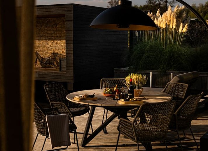 Ontspannen terras bij Vakantiehuisje in Kortenhoef, Noord-Holland zuid, met zitje in de ochtendzon.