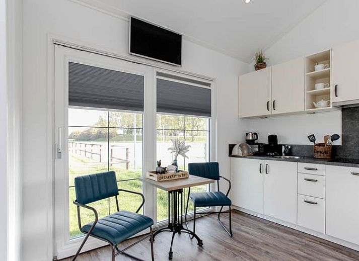 Geniessen Sie den laendlichen Charme im Ferienhaus in Nieuw Vennep, Nordholland, mit grasenden Tieren vor einem rustikalen Ferienhaus.