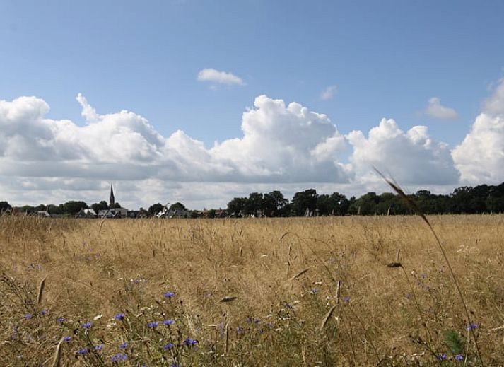 Willkommensschild am Eingang des Ferienhauses in Mander, Twente, Overijssel, umgeben von schoenen Blumen und Gruenanlagen.