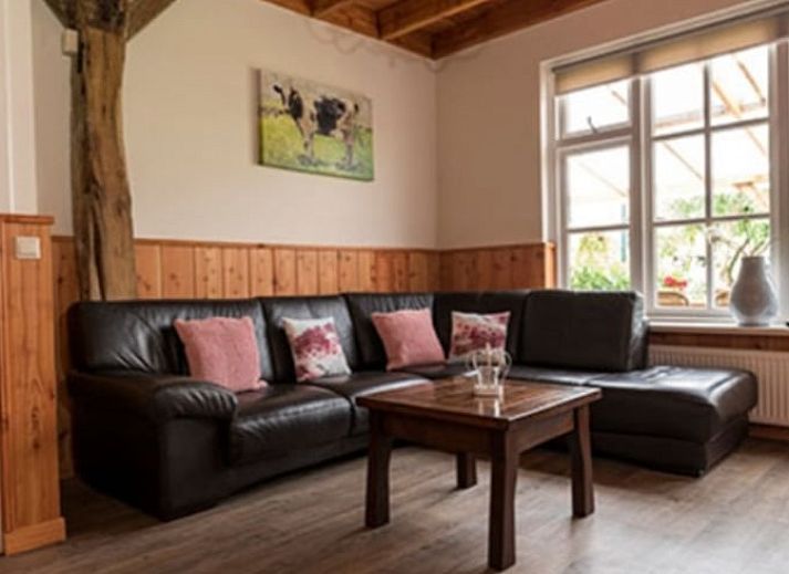 Gezellige eetkamer in vakantiehuisje in Mander, Twente, met houten interieur en lange tafel.