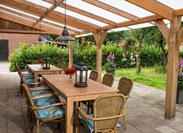 Gezellige eetkamer in vakantiehuisje in Mander, Twente, met houten interieur en lange tafel.
