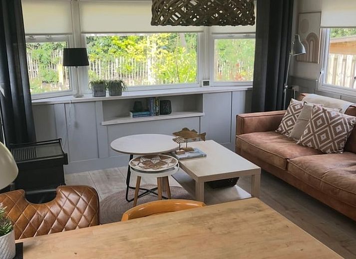 Gezellige woonkamer in Huisje in Nutter, vakantiehuis in Twente, met comfortabele zithoek en uitzicht op groene omgeving in Overijssel.