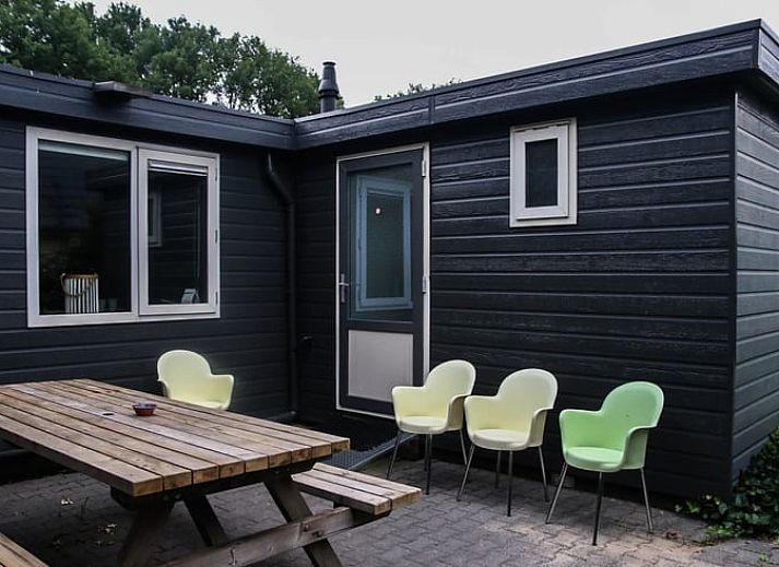 Geraeumiges Wohnzimmer von Huisje in Den Ham, Ferienhaus in Twente, Overijssel, mit gemuetlicher Sitzecke und langem Esstisch fuer Familienaufenthalte.