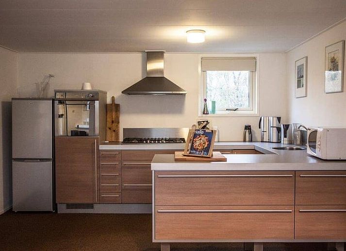 Geraeumiges Wohnzimmer von Huisje in Den Ham, Ferienhaus in Twente, Overijssel, mit gemuetlicher Sitzecke und langem Esstisch fuer Familienaufenthalte.