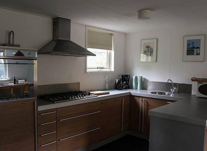 Geraeumiges Wohnzimmer von Huisje in Den Ham, Ferienhaus in Twente, Overijssel, mit gemuetlicher Sitzecke und langem Esstisch fuer Familienaufenthalte.