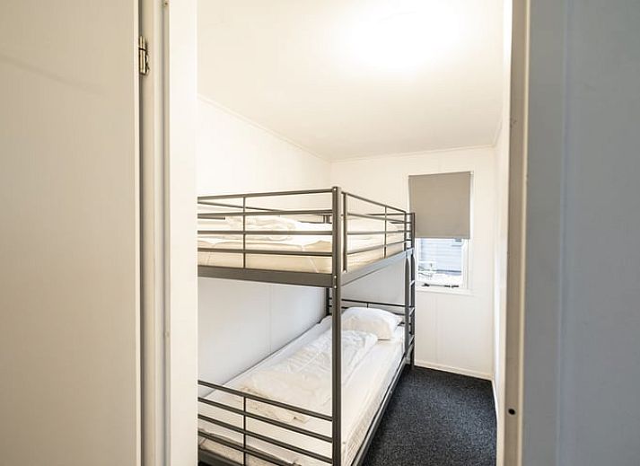 Gemuetliches Ferienhaus Cottage in Den Ham in der gruenen Natur von Twente, Overijssel, mit einladender Veranda und umgeben von ueppiger Vegetation.