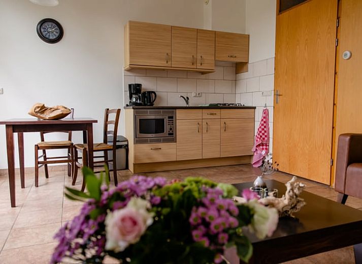 Gemuetliche Kueche im Ferienhaus in Den Ham, Twente mit Holzschraenken und Essecke, ideal fuer einen entspannten Aufenthalt in Overijssel.