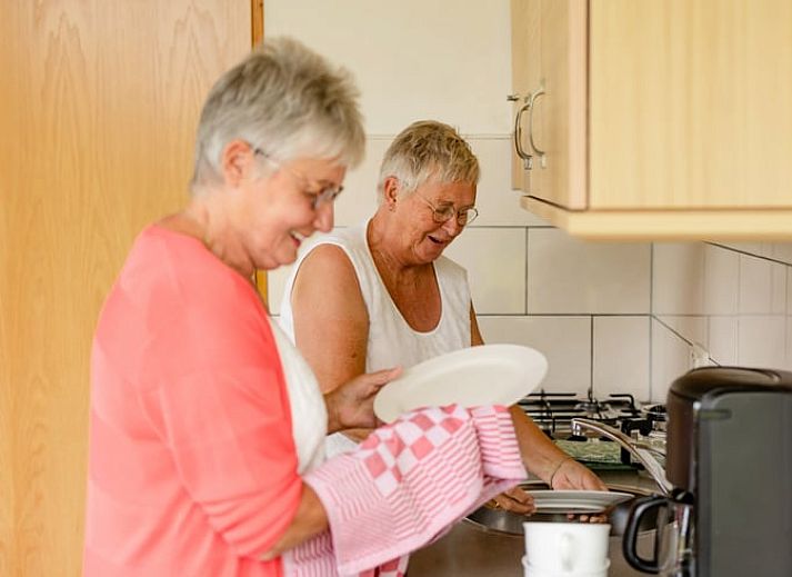 Gemuetliche Kueche im Ferienhaus in Den Ham, Twente mit Holzschraenken und Essecke, ideal fuer einen entspannten Aufenthalt in Overijssel.