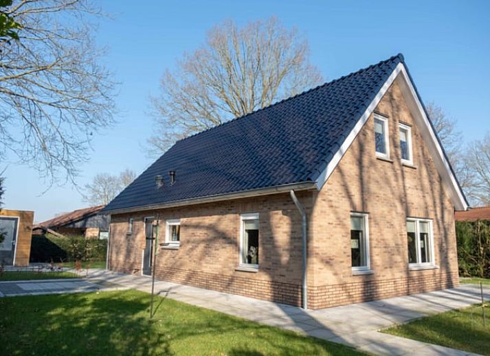 Buitenkant van Vakantiehuisje in Den Ham, Twente, omringd door groene tuin en charmante paden.