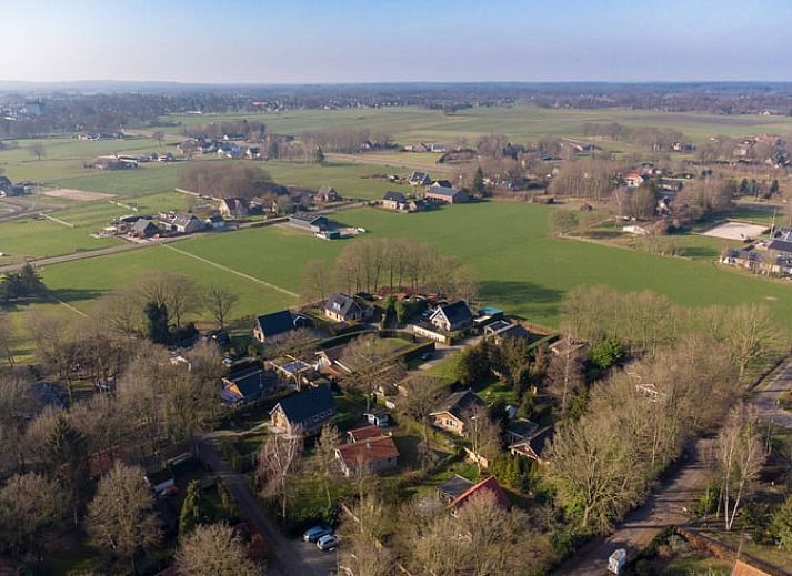 Buitenkant van Vakantiehuisje in Den Ham, Twente, omringd door groene tuin en charmante paden.