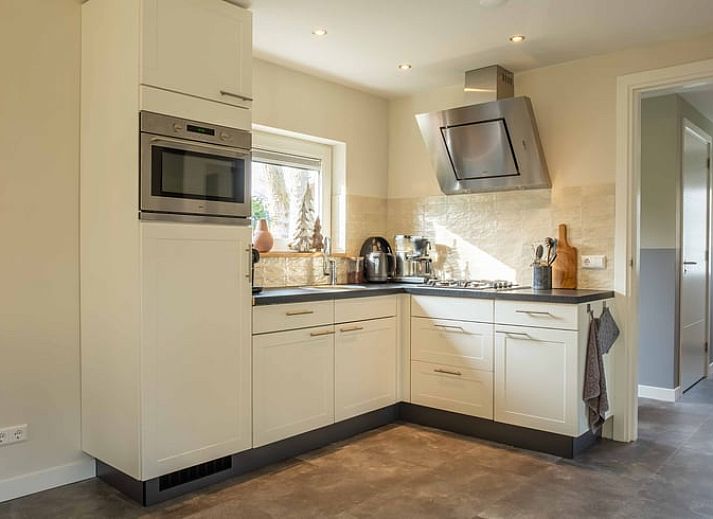 Buitenkant van Vakantiehuisje in Den Ham, Twente, omringd door groene tuin en charmante paden.