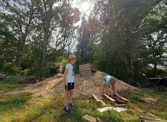 Family enjoys a game on the terrace of Huisje in Den Ham, a vacation home in green Twente, Overijssel.