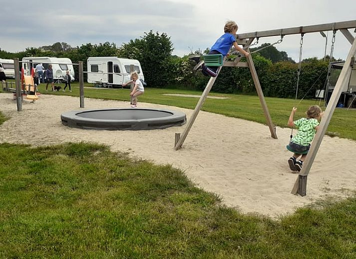 Family enjoys a game on the terrace of Huisje in Den Ham, a vacation home in green Twente, Overijssel.