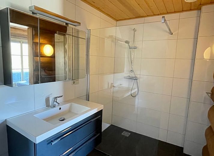 Gemuetliches Wohnzimmer im Ferienhaus in Den Ham, Twente, Overijssel. Inneneinrichtung aus Holz mit bequemen Sitzgelegenheiten und rustikalem Charme.