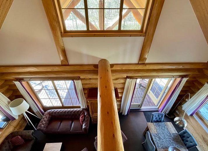 Gemuetliches Wohnzimmer im Ferienhaus in Den Ham, Twente, Overijssel. Inneneinrichtung aus Holz mit bequemen Sitzgelegenheiten und rustikalem Charme.