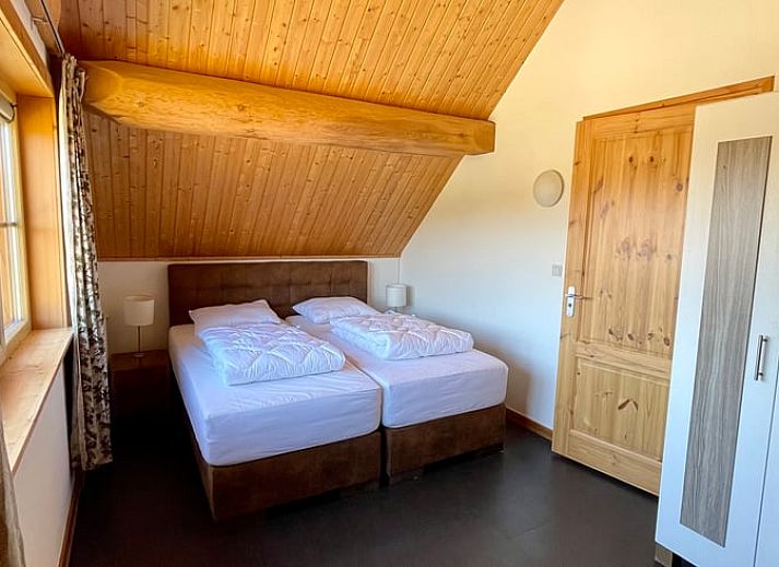 Gemuetliches Wohnzimmer im Ferienhaus in Den Ham, Twente, Overijssel. Inneneinrichtung aus Holz mit bequemen Sitzgelegenheiten und rustikalem Charme.