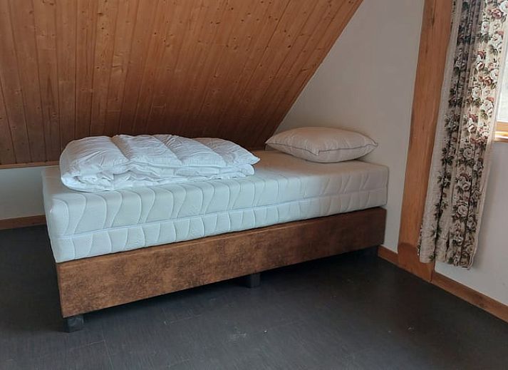 Gemuetliches Wohnzimmer im Ferienhaus in Den Ham, Twente, Overijssel. Inneneinrichtung aus Holz mit bequemen Sitzgelegenheiten und rustikalem Charme.