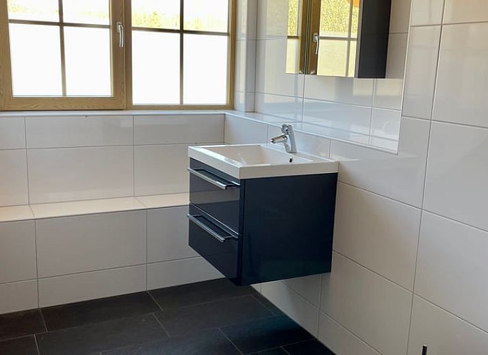 Gemuetliches Wohnzimmer im Ferienhaus in Den Ham, Twente mit Holzinterieur und Blick auf die natuerliche Umgebung von Overijssel.