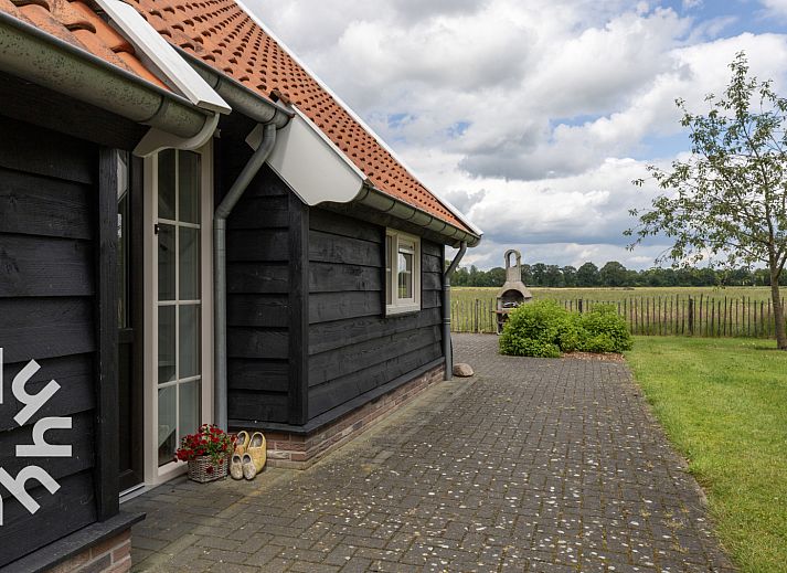 Inkomhal van vakantiehuis OV404 in Den Ham, Twente met moderne trap en deur naar de tuin.